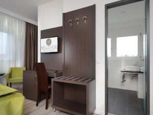 a room with a desk and a table and a kitchen at Boutique Hotel Bellevue Rheinfelden / Basel in Rheinfelden