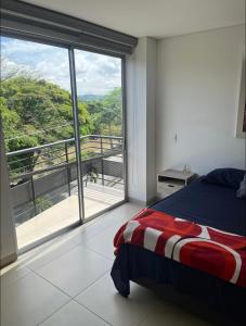 une chambre avec un lit et une grande fenêtre dans l'établissement Moderno Penthouse cartago centro vista al rio, à Cartago