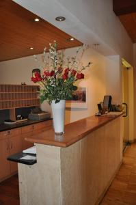 a vase of flowers on a counter in a kitchen at Hotel Andino Club - Hotel Asociado Casa Andina in Huaraz