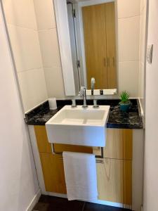 un bagno con un lavandino bianco e uno specchio di Villa General Belgrano Lago Los Molinos a Potrero de Garay