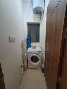 een kleine badkamer met een wasmachine en een wasmachine bij B&S Accommodation Solitary Duplex Maisonette in Żejtun