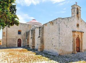 an old stone building with a cross on top at B&S Accommodation Newly Renovated Penthouse 253 in Żejtun