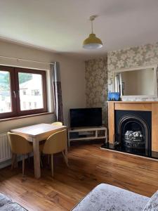 a living room with a table and a fireplace at Lovely 2 bedroom family apartment in Newcastle in Newcastle