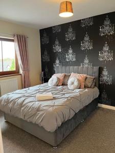 a bedroom with a large bed with a black wall at Lovely 2 bedroom family apartment in Newcastle in Newcastle