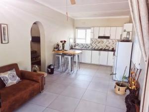 a living room with a couch and a kitchen at Three Two in Richards Bay