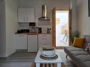 cocina y sala de estar con mesa y sofá. en Apartamento La Zarzamora-Patio privado, en Jerez de la Frontera