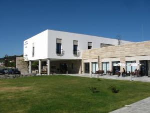 a white building with a lawn in front of it at HI Alijo - Pousada de Juventude in Alijó