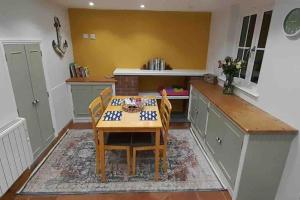 eine Küche mit einem Tisch und Stühlen im Zimmer in der Unterkunft Willow Cottage Cosy Cornish Rural Retreat - Dog Friendly Cornwall in Ponsanooth