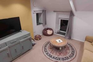 ein Wohnzimmer mit einem TV und einem Couchtisch in der Unterkunft Willow Cottage Cosy Cornish Rural Retreat - Dog Friendly Cornwall in Ponsanooth