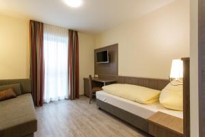 una camera d'albergo con letto e scrivania di CityApart Hotel a Dingolfing