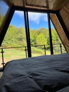 Bett in einem Zimmer mit einem großen Fenster in der Unterkunft V house Goc 