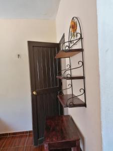 une chambre avec une porte, une étagère et une table dans l'établissement Casita Esmeralda, à El Cuyo