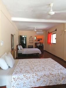 een slaapkamer met 2 bedden en een woonkamer bij Casita Esmeralda in El Cuyo