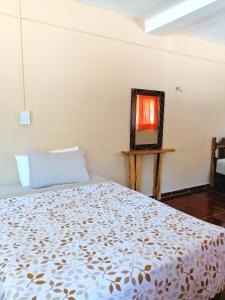 - une chambre avec un lit et une télévision sur une table dans l'établissement Casita Esmeralda, à El Cuyo
