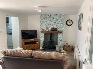 a living room with a couch and a tv at Lovely 1 bed flat 200 metres from beach in Walton-on-the-Naze