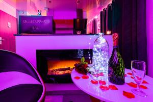 ディジョンにあるGlamappartSpa design luxe & Parkingのワイングラスと暖炉付きのテーブル