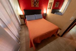 a bedroom with a bed with an orange blanket and a mirror at Cabañas Marjumi in Mar de las Pampas +72 photos