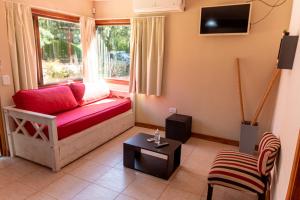 a living room with a red couch and a window at Cabañas Marjumi in Mar de las Pampas