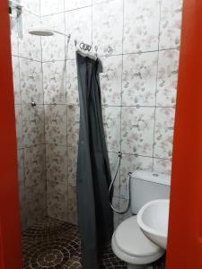 a bathroom with a toilet and a sink at Albergue Flor do Caribe in Parintins