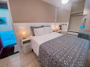 a bedroom with a large bed and a mirror at Casa Vila da Praia Buzios - Centro in Búzios