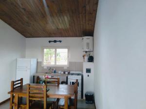 - une cuisine avec un plafond en bois, une table et des chaises dans l'établissement Primero de Abril, à Villa General Belgrano