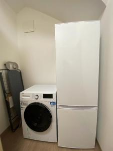 a white refrigerator and a washing machine in a room at OASIS: Close to Munich - 4 Bedrooms - Kitchen in Dachau
