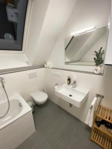 a white bathroom with a sink and a toilet at OASIS: Close to Munich - 4 Bedrooms - Kitchen in Dachau