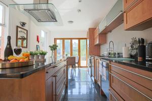 a large kitchen with wooden cabinets and a counter top at Thrift House - Central Location - Free Parking, Pool Table, Fast Wifi, Smart TV with Fast Wifi by Yoko Property in Northampton