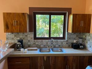 cocina con fregadero y ventana en Bliss Apartments Holbox, en Isla Holbox