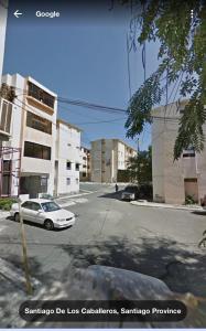a street with a white car parked on the street at 8 Santiago Monumental Area Cozy and lovely apartment to enjoy 3 bedrooms Apartment transportation 24 hours in Santiago de los Caballeros