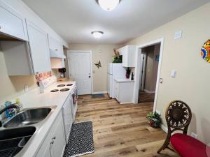 a kitchen with white cabinets and a wooden floor at Talavera in Salem