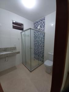 a bathroom with a glass shower and a toilet at Hospedaria São João in Mucugê