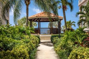 a gazebo in a garden with palm trees at Sea Esta Studio I - Ideal for Couples! in Turtle Cove