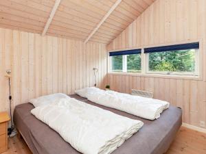 Holiday Home Marionsvej في Trend: سريرين في غرفة بجدران خشبية