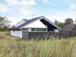 a black and white house in the middle of a field at Holiday home Thisted XLIX in Thisted