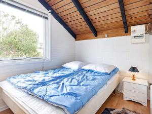 a bedroom with a large bed with a window at Holiday home Thisted XLIX in Thisted