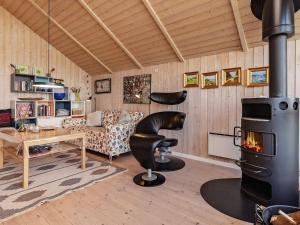 sala de estar con estufa de leña y sofá en Three-Bedroom Holiday home in Højslev 4, en Bøstrup