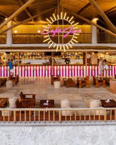 a restaurant with wooden tables and a large clock at Café Jeri Hotel in Jericoacoara