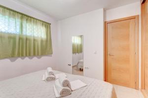 Un dormitorio blanco con una cama con toallas blancas. en SELF Check-in Duplex in San Juan with 2 bedrooms en Guía de Isora