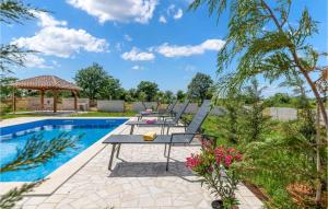 un patio con mesas y sillas junto a una piscina en Nice Home In Sisan With Kitchen, en Šišan