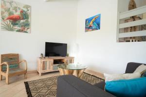 un salon avec un canapé et une télévision dans l'établissement Villa Green Caraibes, à Saint-François