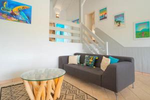 un salon avec un canapé et une table en verre dans l'établissement Villa Green Caraibes, à Saint-François 13 autres photos