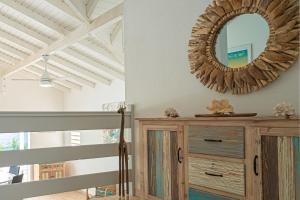 un miroir sur un mur au-dessus d'une commode dans une pièce dans l'établissement Villa Green Caraibes, à Saint-François
