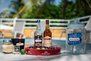 une table avec deux bouteilles d'alcool et un bol de boissons dans l'établissement Villa Green Caraibes, à Saint-François