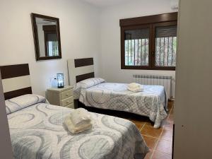 um quarto com três camas e um espelho em Villa Emilia 2 em Ossa de Montiel