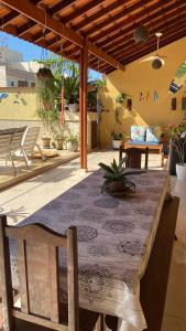 a wooden table with a table cloth on a patio at casa 300 mts da praia in Juquei