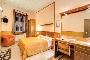 a hotel room with a bed and a desk at Hotel Lorena in Florence