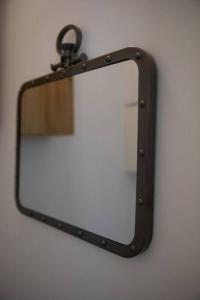 un espejo con un marco de metal negro y un reflejo en él en Studio Soualiga Orient Bay en Saint Martin