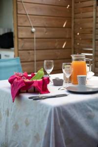 una mesa con mantel blanco y vasos de zumo de naranja en Studio Soualiga Orient Bay en Saint Martin