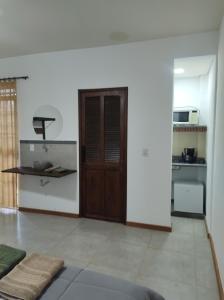 a living room with a door and a kitchen at Hostel Dom Bosco in São João del Rei